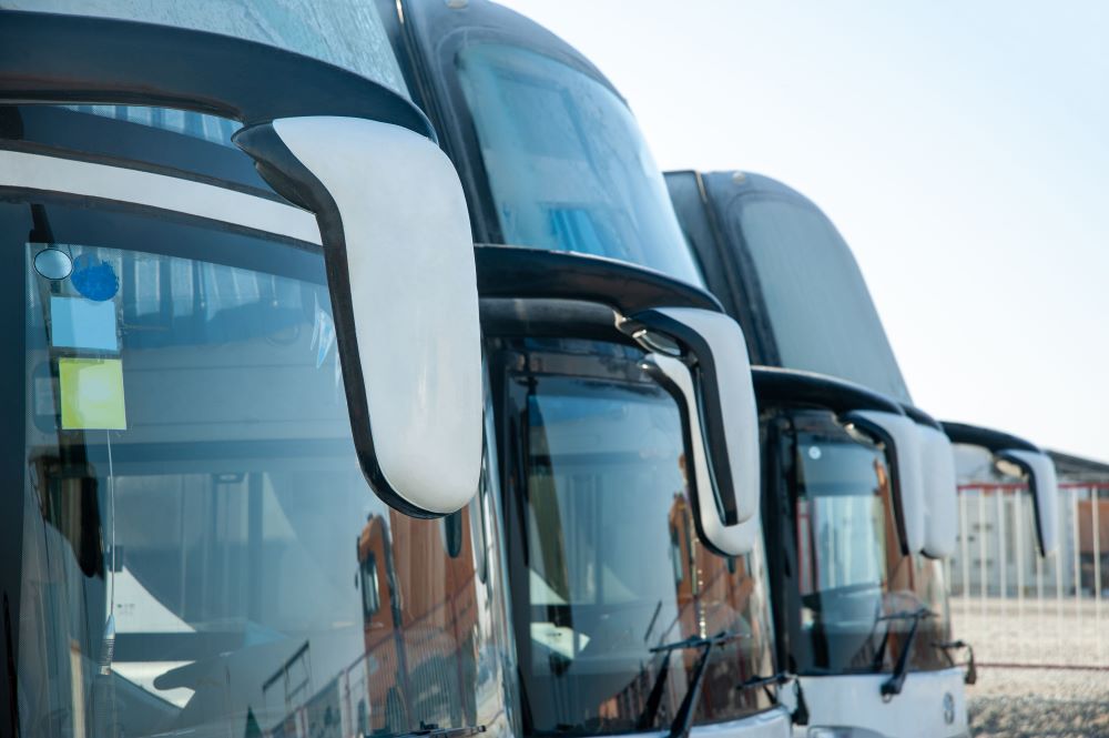 A detail of a row of luxury buses parked on the construction site for transporting a team